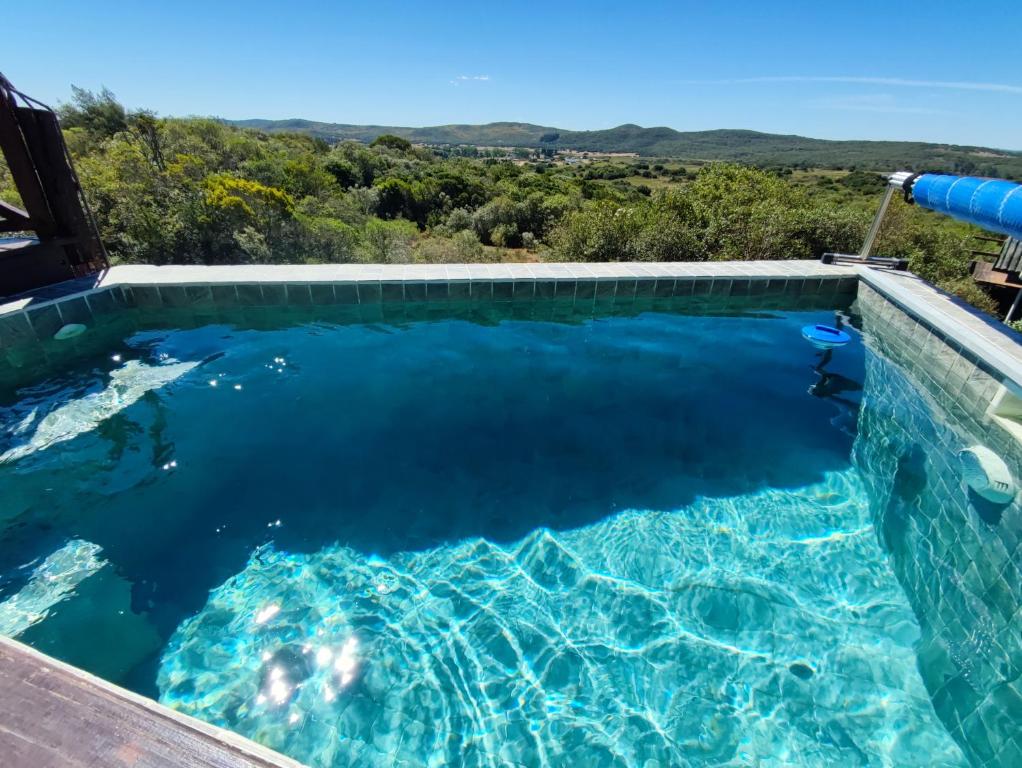 a swimming pool with a view of the ocean at Cabaña Panambi in Villa Serrana