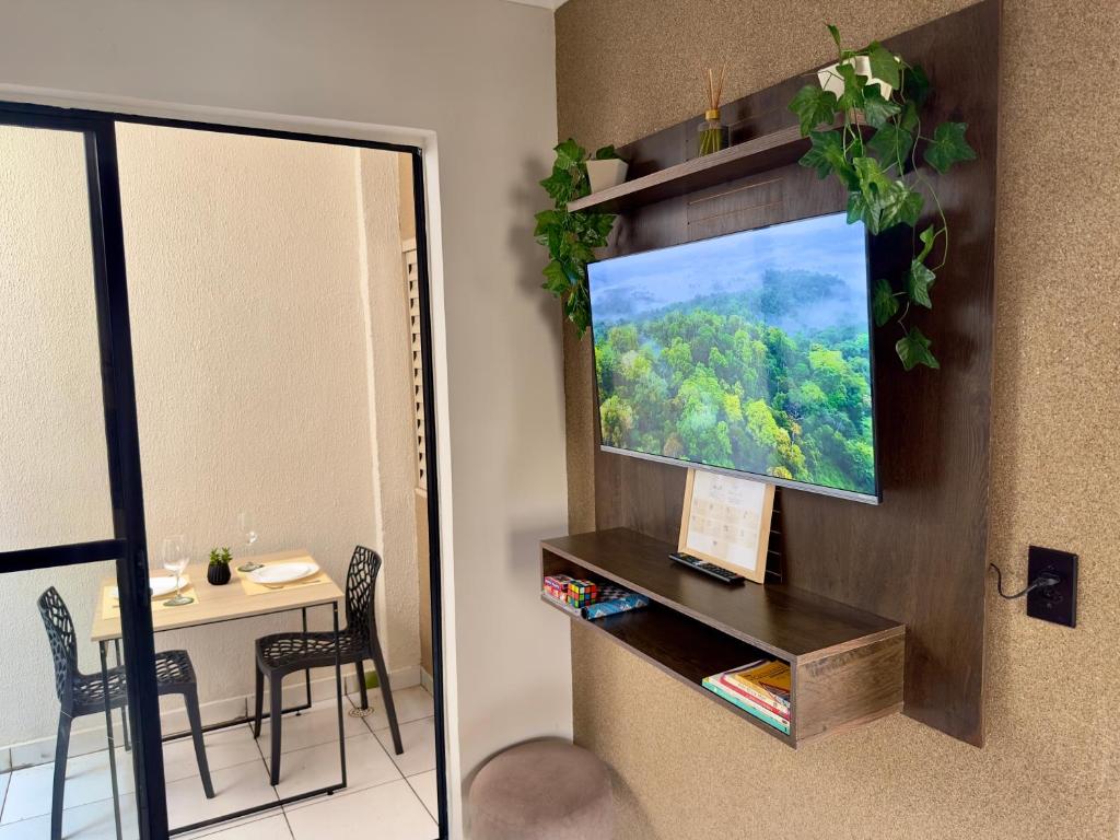 a living room with a television on a wall at Apartamento Central in Passos