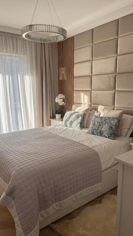 a bedroom with a large bed with a large headboard at Nowoczesny Apartament Tatarska in Przemyśl