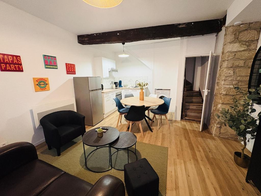 a living room with a table and chairs and a kitchen at La coloc' l 3 Chambres avec salle de bain & TV in Castres