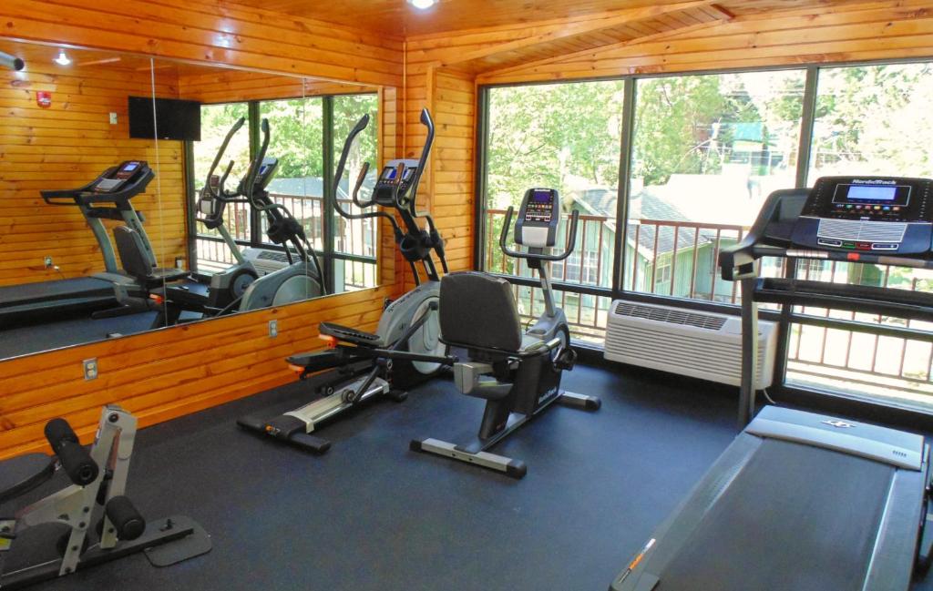 a gym with three exercise bikes and a balcony at Baymont by Wyndham Gatlinburg On The River in Gatlinburg