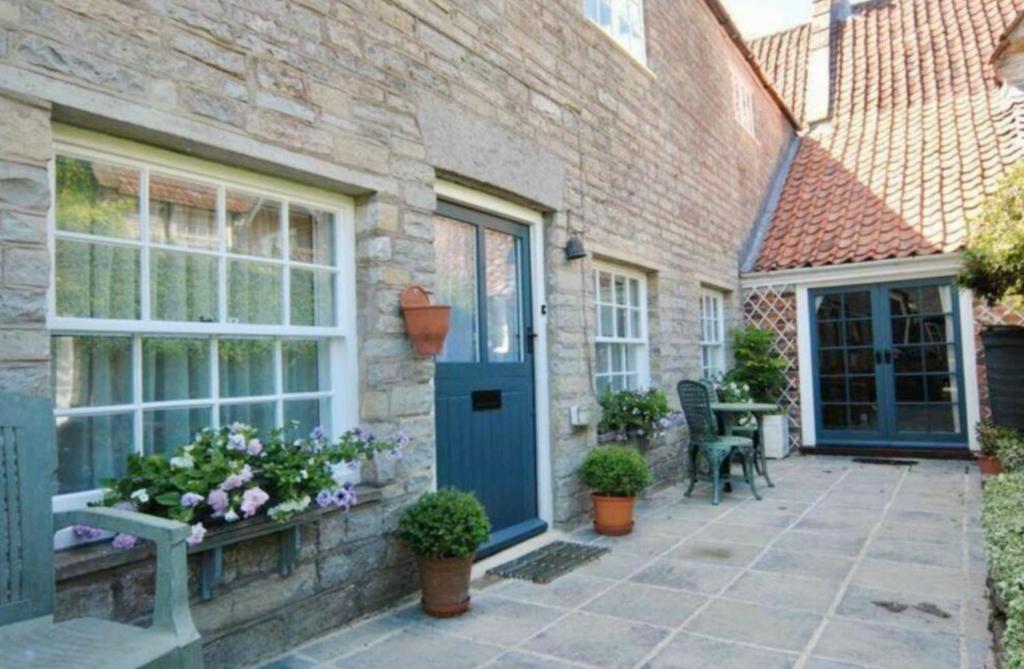 a brick house with a blue door and a patio at The Somerton Hideaway in Somerton