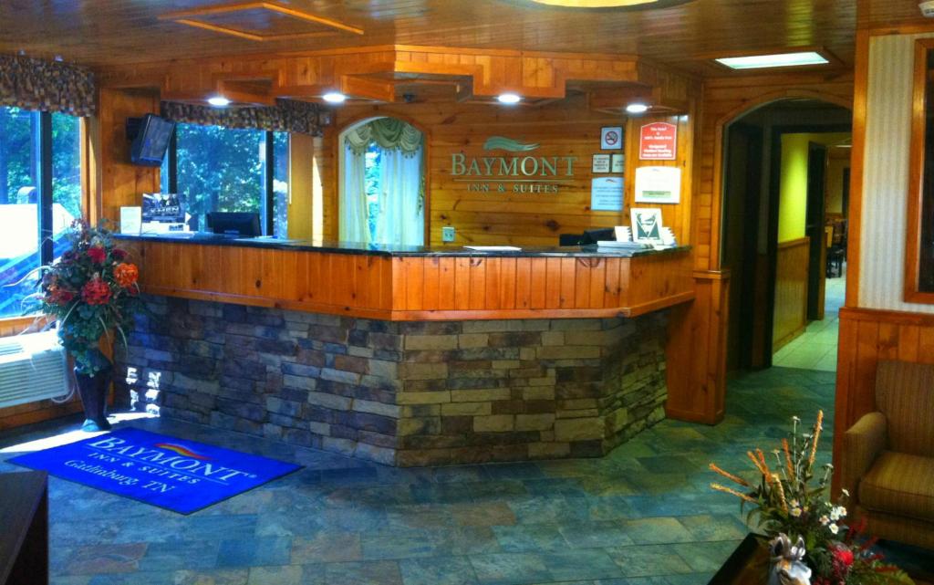 a bar in a restaurant with a brick wall at Baymont by Wyndham Gatlinburg On The River in Gatlinburg