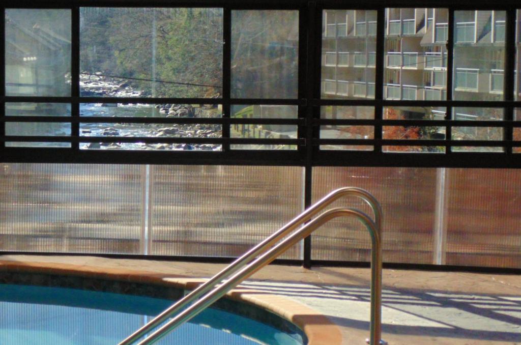 a swimming pool with a hand rail in front of a window at Baymont by Wyndham Gatlinburg On The River in Gatlinburg