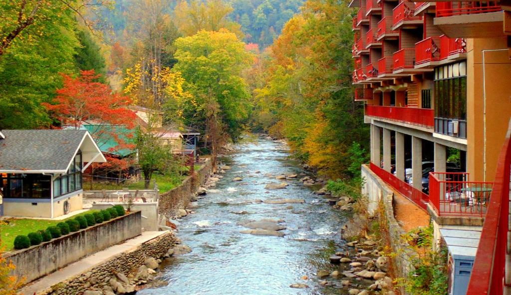 a river in a town with buildings and trees at Baymont by Wyndham Gatlinburg On The River in Gatlinburg