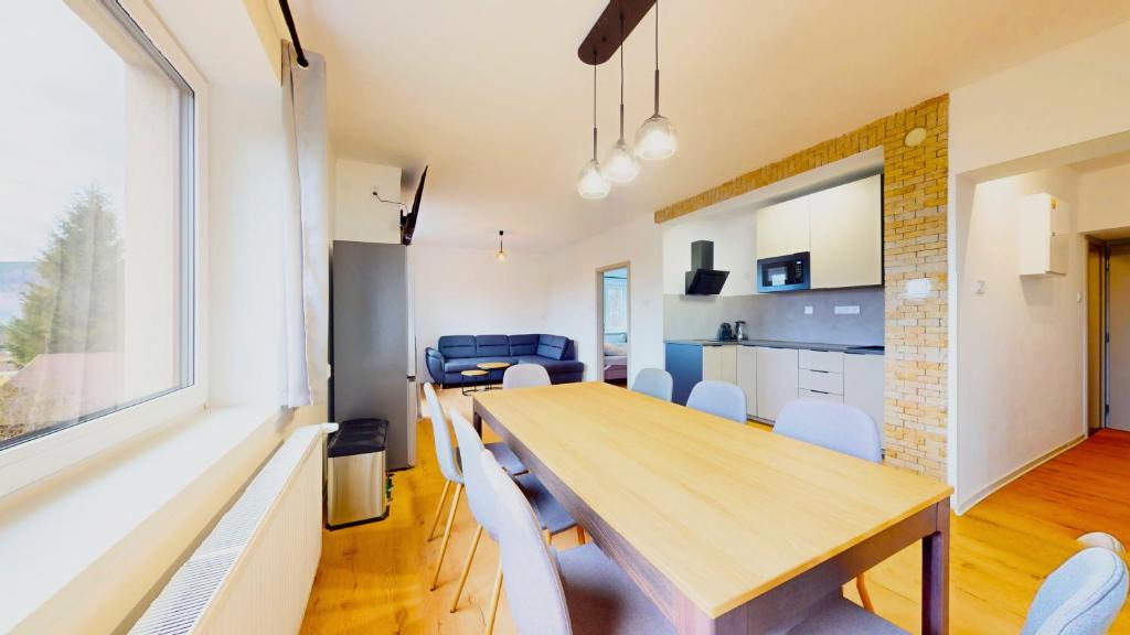 a kitchen and dining room with a wooden table and chairs at Villa Montis in Deštné v Orlických horách