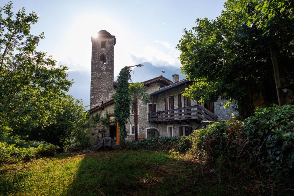 an old stone house with a chimney on top of it at Campanile Nero in Prata Camportaccio