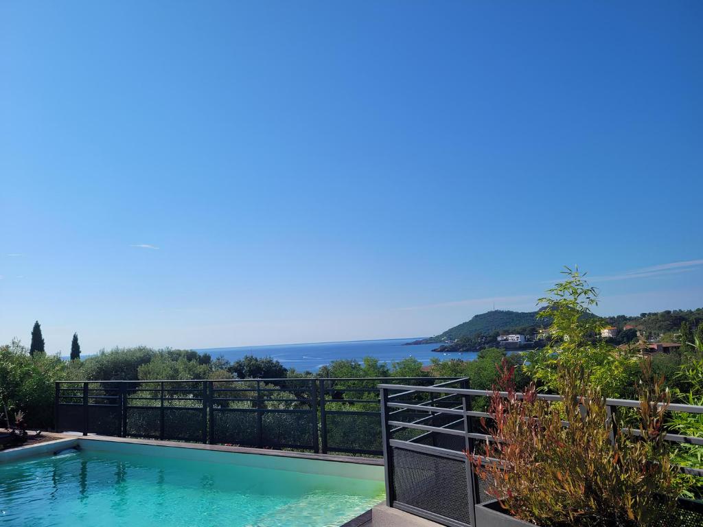 a swimming pool with a view of the ocean at Architect-designed villa, overlooking Agay Bay in Saint-Raphaël