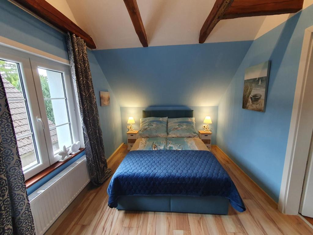 a bedroom with blue walls and a bed with blue sheets at Santa Maria in Ferdinandshof