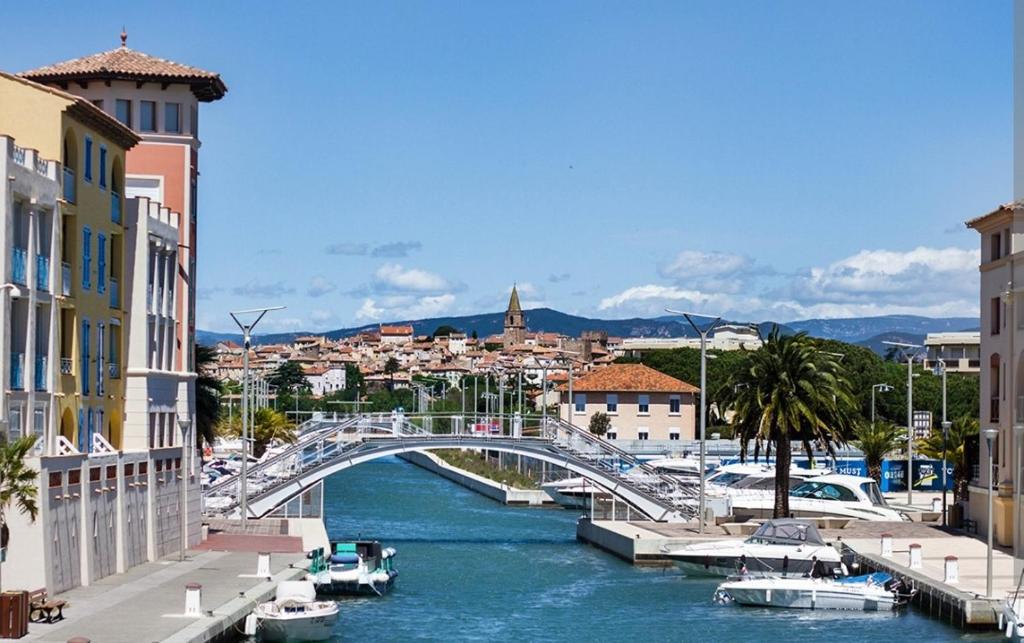 un ponte su un fiume con barche in città di Chambre hôtes à louer Port-Fréjus a Fréjus