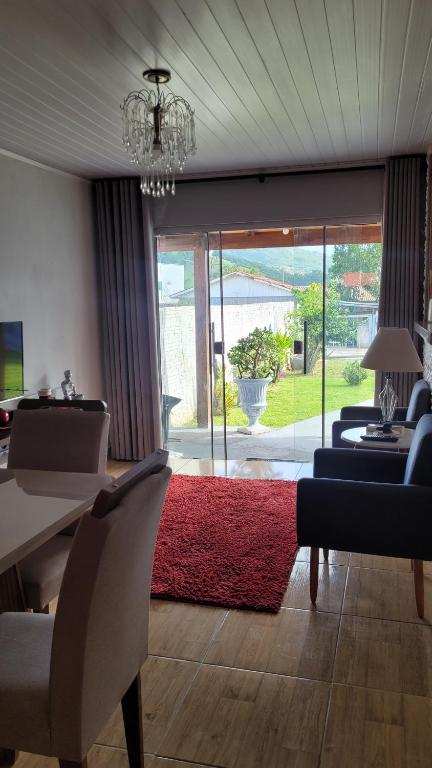 a living room with a red rug and a table and chairs at Moradas Jane in Paulo Lopes