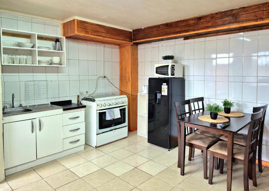 een keuken met een tafel en een zwarte koelkast bij Departamento bahia fonck in Puerto Montt