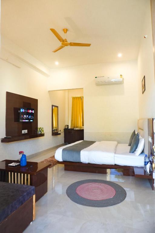 a bedroom with two beds and a ceiling fan at Hariom Tatsat Retreat in Pushkar