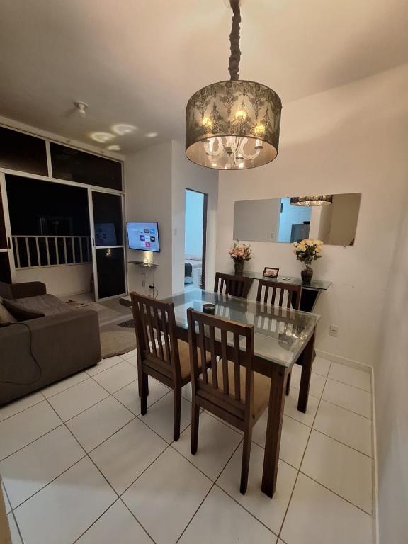 a dining room and living room with a table and chairs at Apartamento Condomínio Turu a 6km da Praia in Maioba