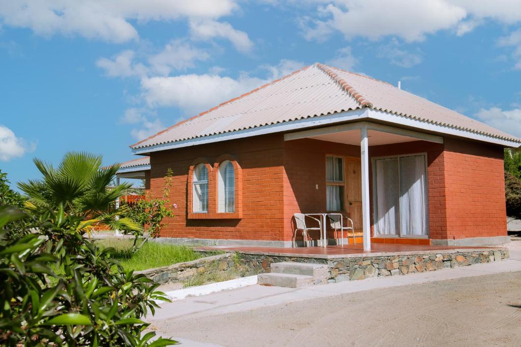 una piccola casa in mattoni rossi con portico di Hotel y Cabañas Portal del Inca a Caldera