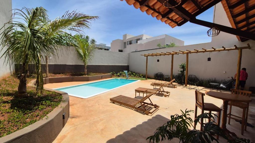 a patio with a swimming pool with chairs and a table at Pousada Carneirinho in Capitólio