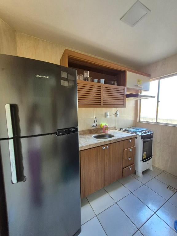 a kitchen with a stainless steel refrigerator and a sink at Em condominio in Parnamirim