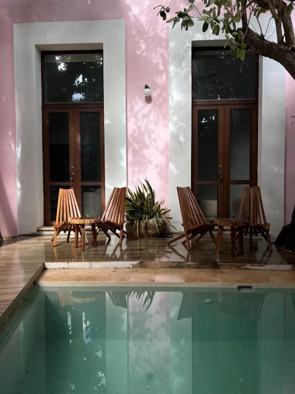 two chairs and a swimming pool in front of a house at Hotelito DELI in Mérida
