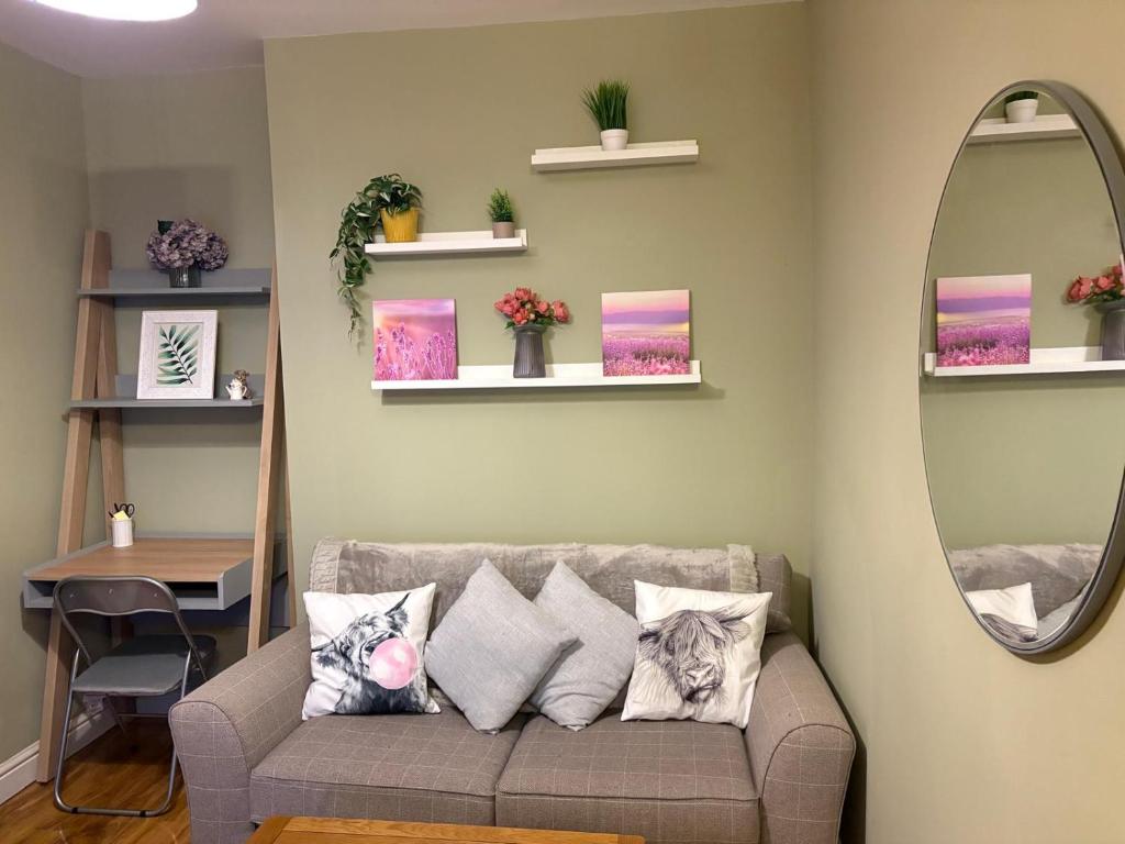 a living room with a couch and a mirror at 13 Chute Street central and homely in Exeter