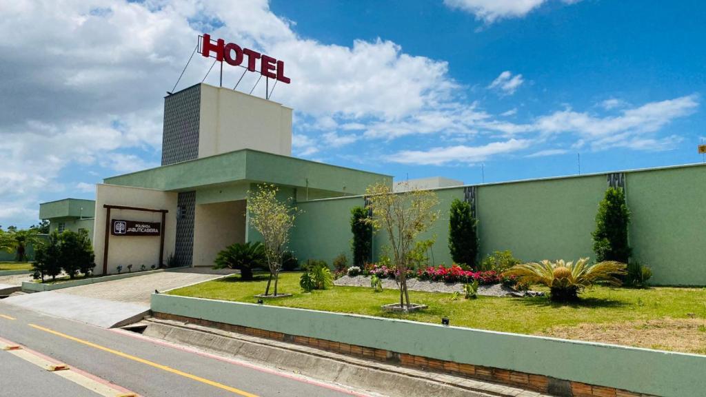 a hotel building with a hotel sign on top of it at Pousada Jabuticabeira in Jaguaruna