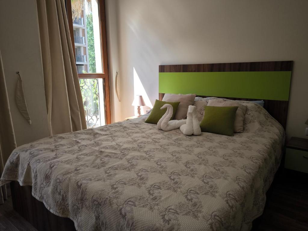 een slaapkamer met een bed met twee knuffels erop bij Cascadas, Studio apartment with a pool view in Sunny Beach