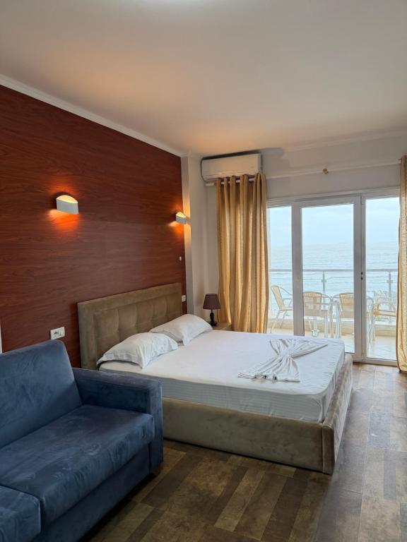 a bedroom with a large bed and a couch at Blumont aparthotel durres in Durrës