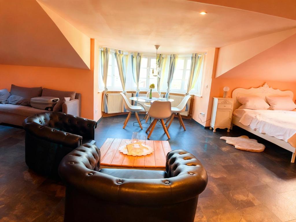 a bedroom with a bed and a couch and a table at Weingut Mathis Apartment 1 Burgblick in Klingenmünster