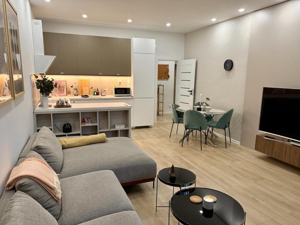 a living room with a couch and a table and a kitchen at Bratislava Cozy Corner Apartment in Vinohrady
