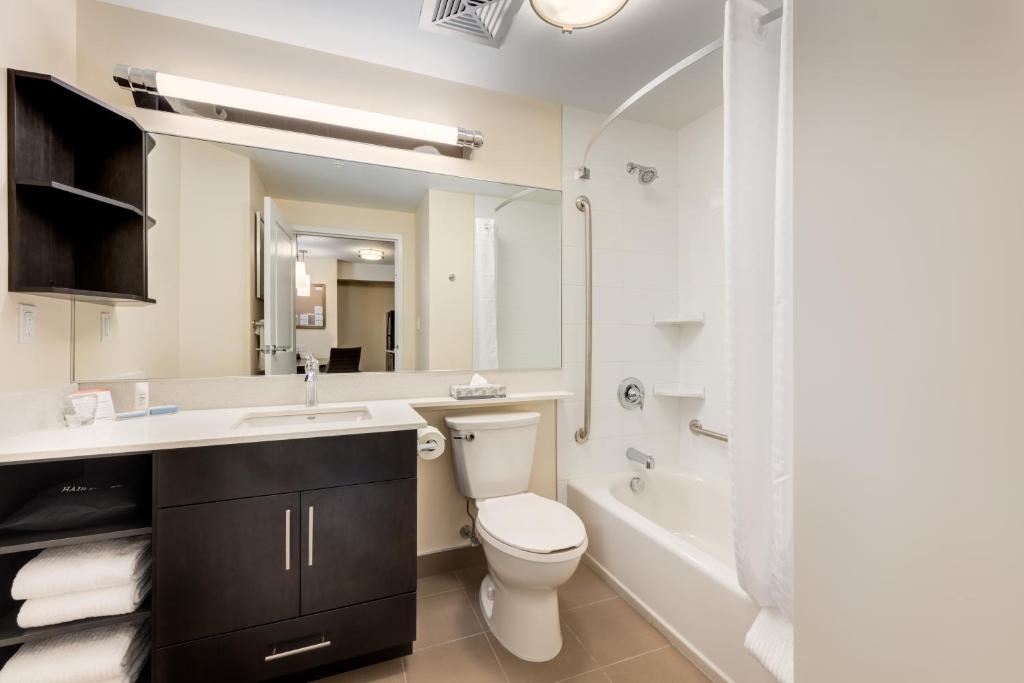 a bathroom with a toilet and a sink and a tub at Park Inn by Radisson, Calgary Airport North, AB in Calgary