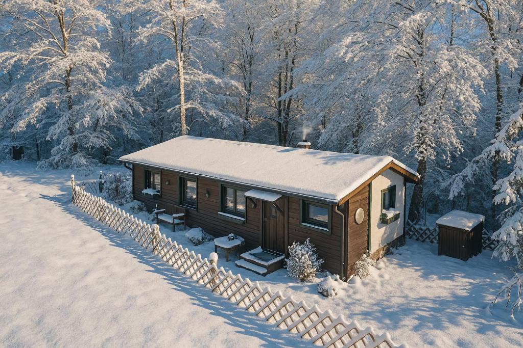una piccola cabina nella neve con alberi innevati di Wildromantische Berghütte mit Traum-Panorama a Haus