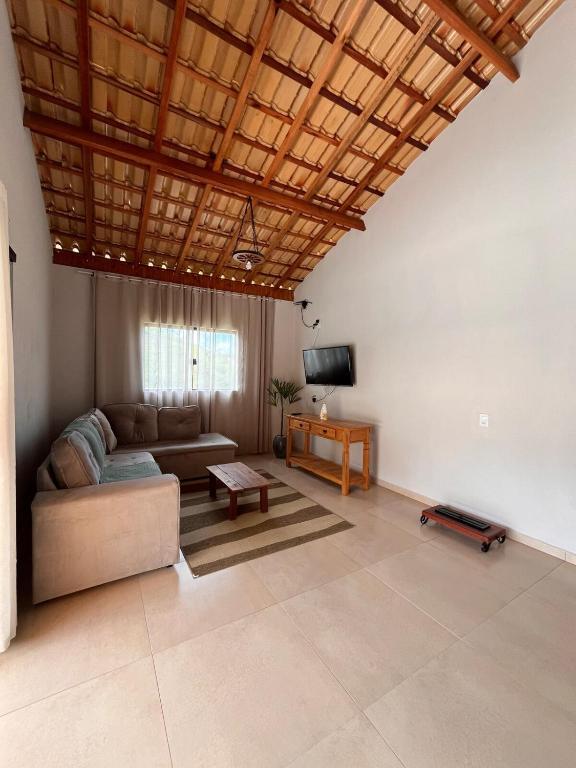 a living room with a couch and a tv at Recanto das Águas in Cunha