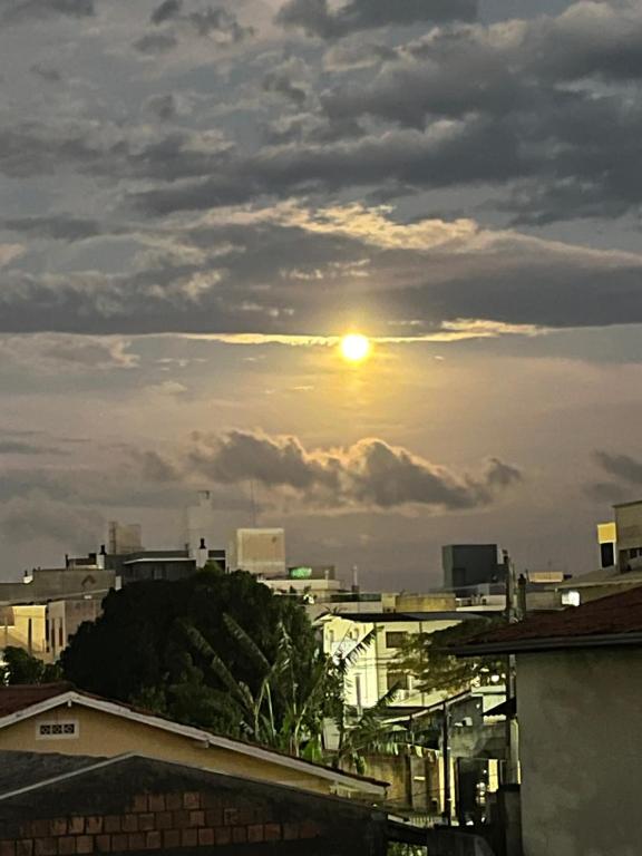 a view of the sun setting over a city at Casa Vidro Mar in Bombinhas