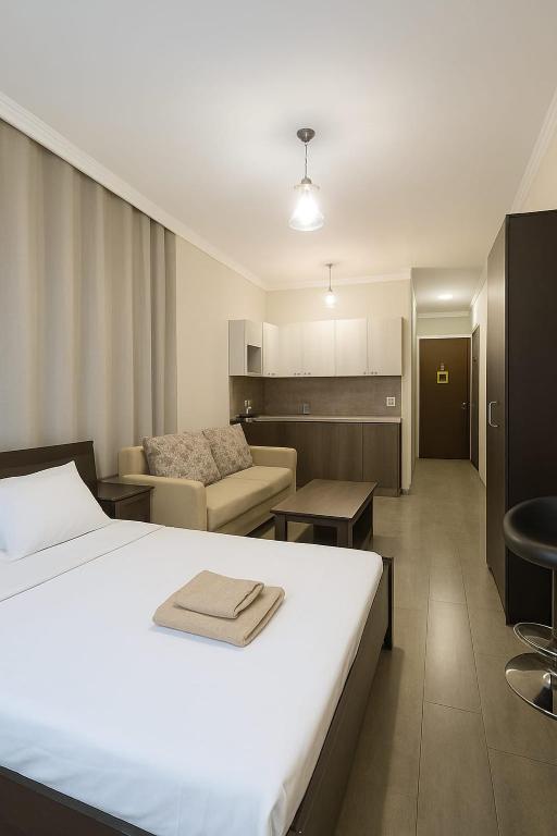 a bedroom with a bed and a living room at Ia's Home in Tbilisi City