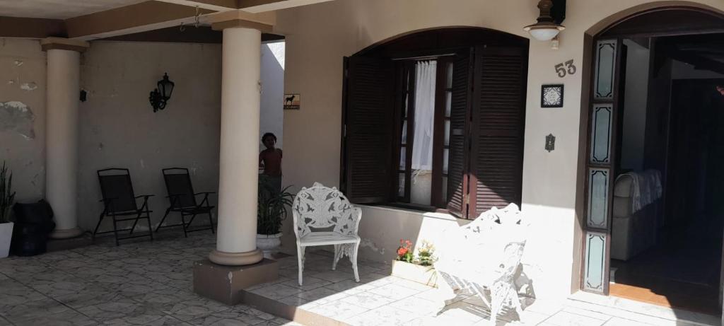 a porch of a house with chairs and a flag at Casa Ximendes in São Gabriel