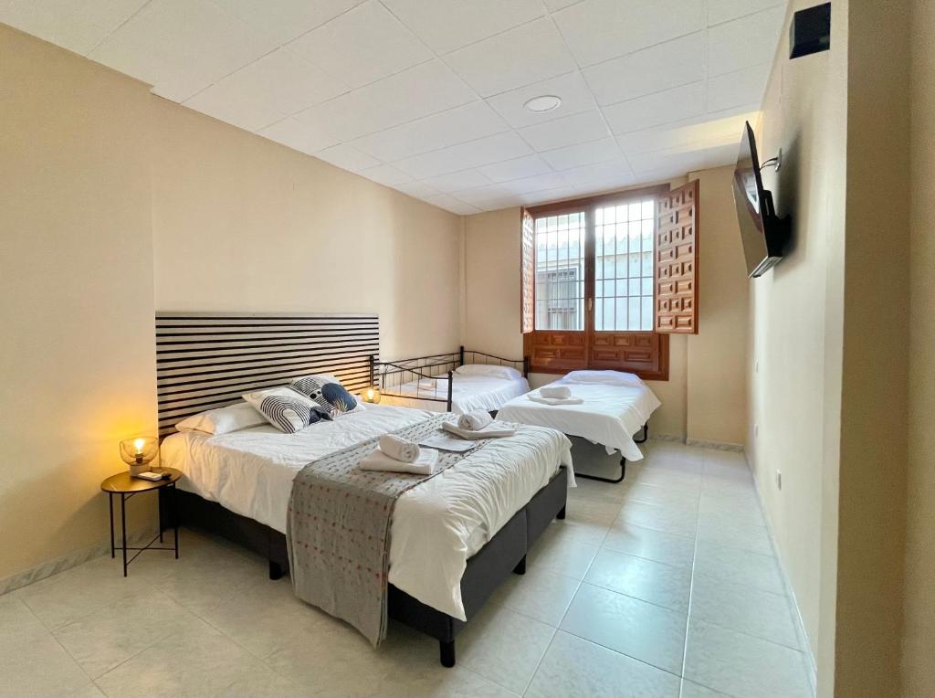 a bedroom with two beds and a window at Júbilus Rooms in Toledo