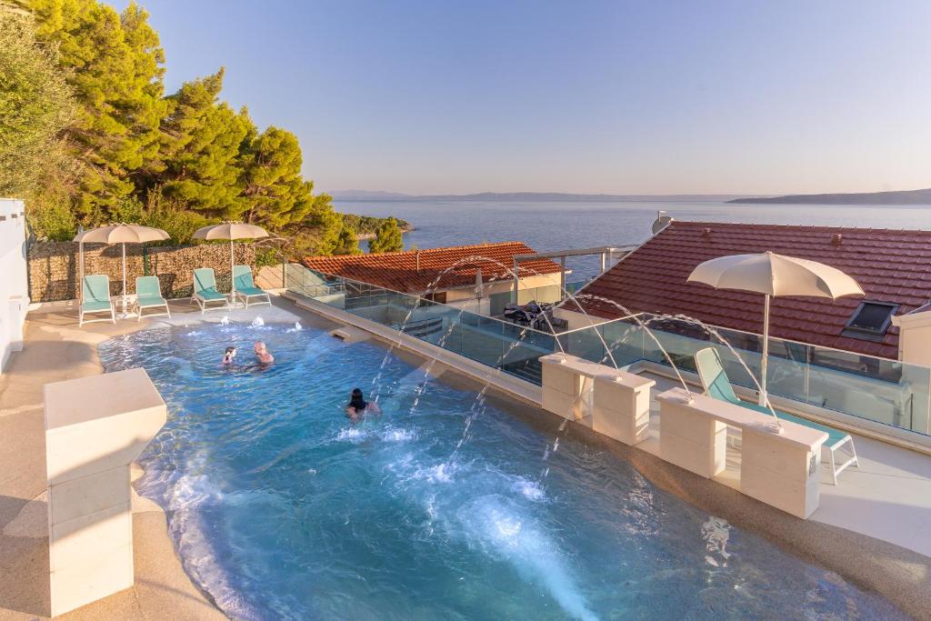 a swimming pool with people in the water at Villa Višnja Prestige in Brela