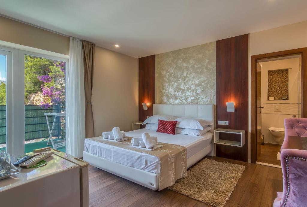 a bedroom with a white bed and a bathroom at Villa Višnja in Brela