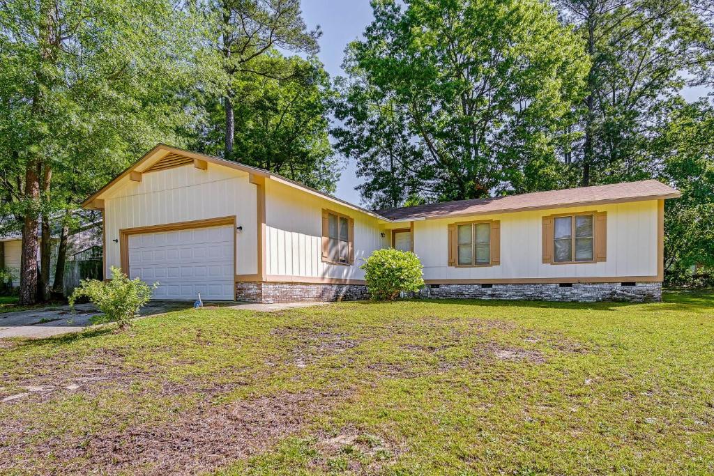 een geel en wit huis met een garage bij Fayetteville Vacation Rental with Yard! in Fort Bragg