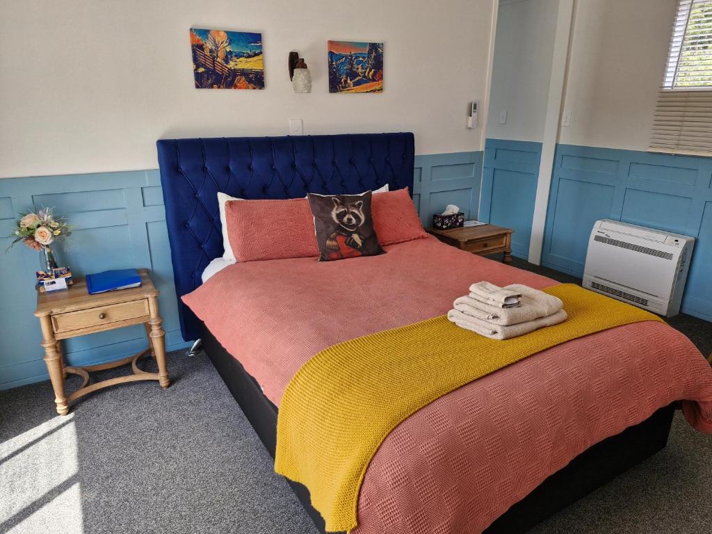 a bedroom with a bed with a blue head board at DuxHouse BnB in Taihape