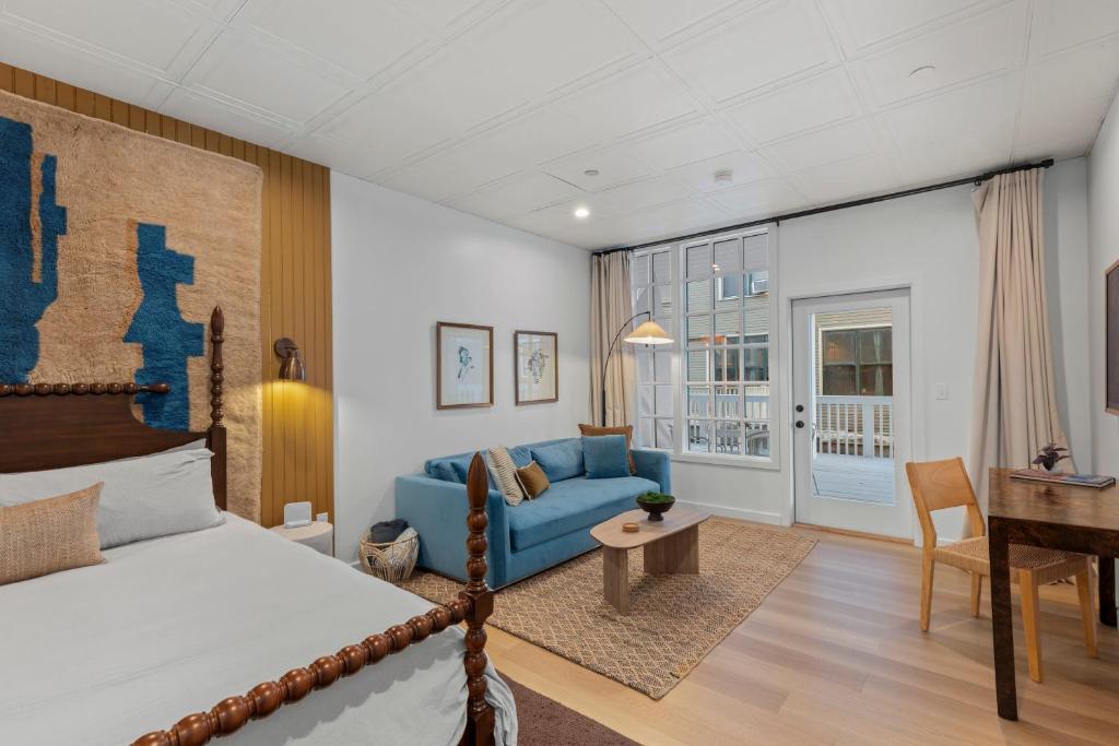 a bedroom with a bed and a couch and a desk at The Optimist Guesthouse | 5 in Camden