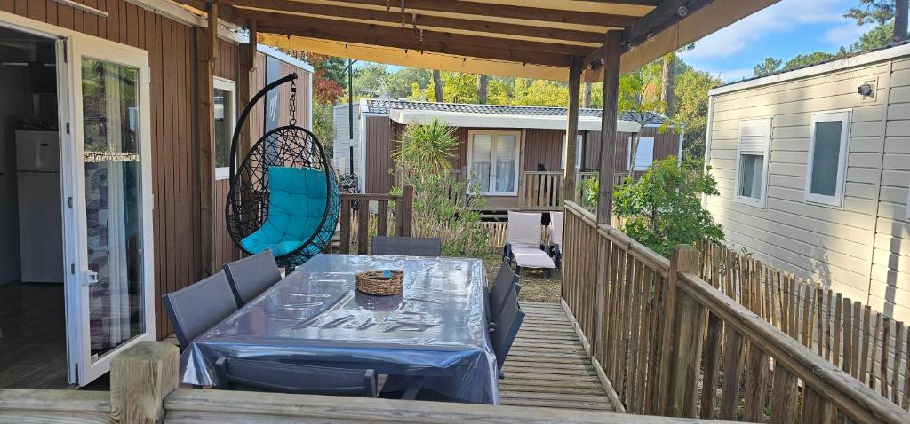 a patio with a table and chairs on a porch at Bienvenue au Cap Ferret in Lège-Cap-Ferret