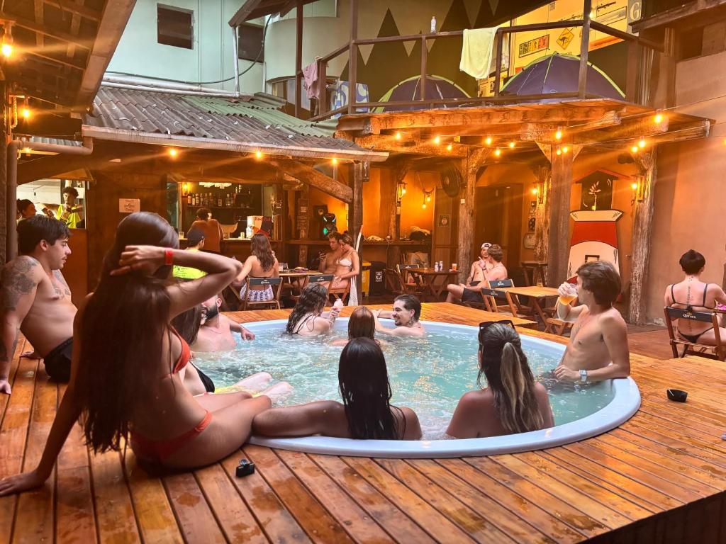 a group of people sitting in a swimming pool at Green Haven Hostel in Ubatuba