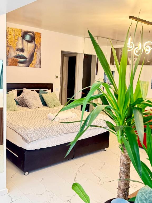 a bedroom with a bed and a plant at InspireNest Iulius Mall in Cluj-Napoca