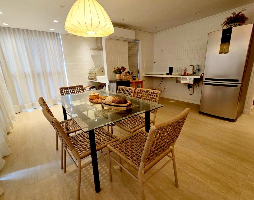 a kitchen with a table with chairs and a refrigerator at Salt Beach Atalaia Fort do Farol in Salinópolis