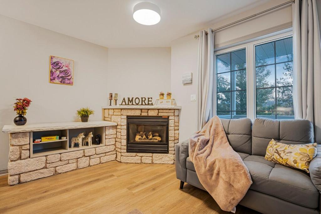 a living room with a couch and a fireplace at Luxury Jacuzzi Suite with Sauna & Heated Pool in Shanty Bay