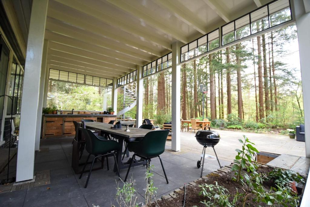 a screened in porch with a table and chairs at Klein Nieuwe Wegen in Ons Belang