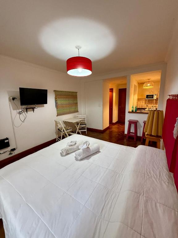 a bedroom with a large white bed with towels on it at Spacious Studio in Alsina in Salta