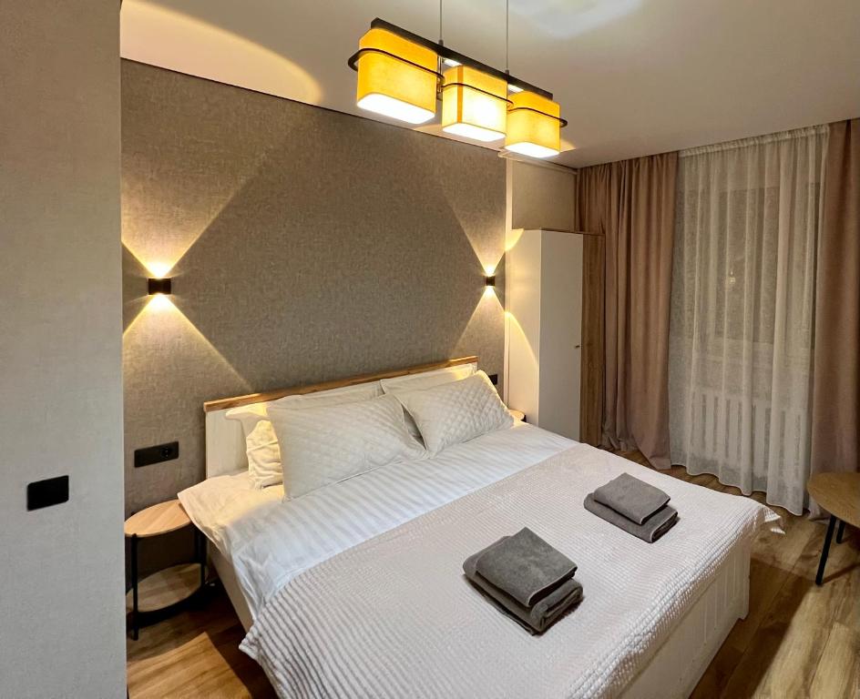 a bedroom with a white bed with two towels on it at Chișinău Airport Comfort in Chişinău