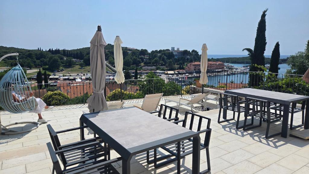 two tables and chairs with umbrellas on a patio at Ferienhaus Topic in Vrsar