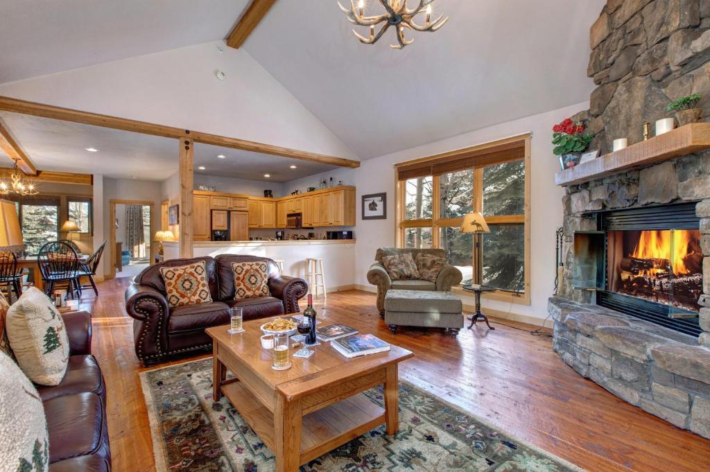 a living room with a stone fireplace at Abode at Moose Creek #21 in Teton Village